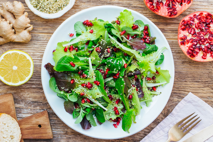 Salad with asian dressing, pomegranate and hemp seeds