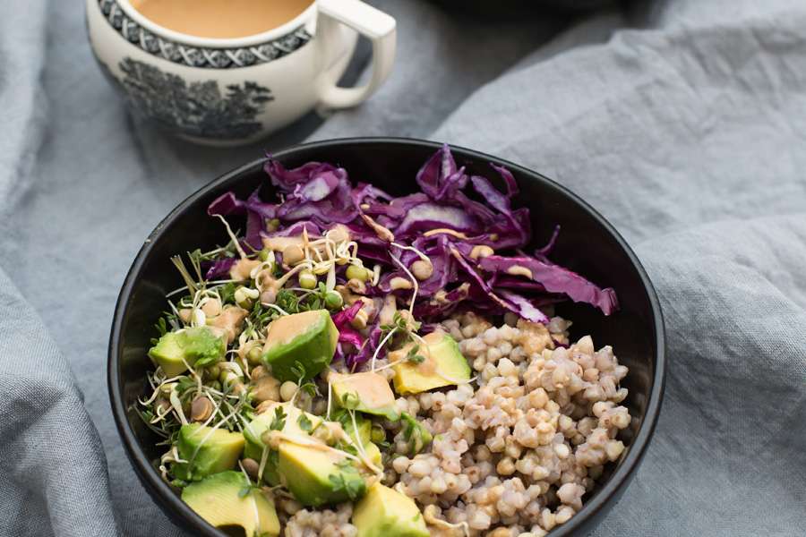 Buckwheat buddha bowl with avocado, red kale and tahini dressing