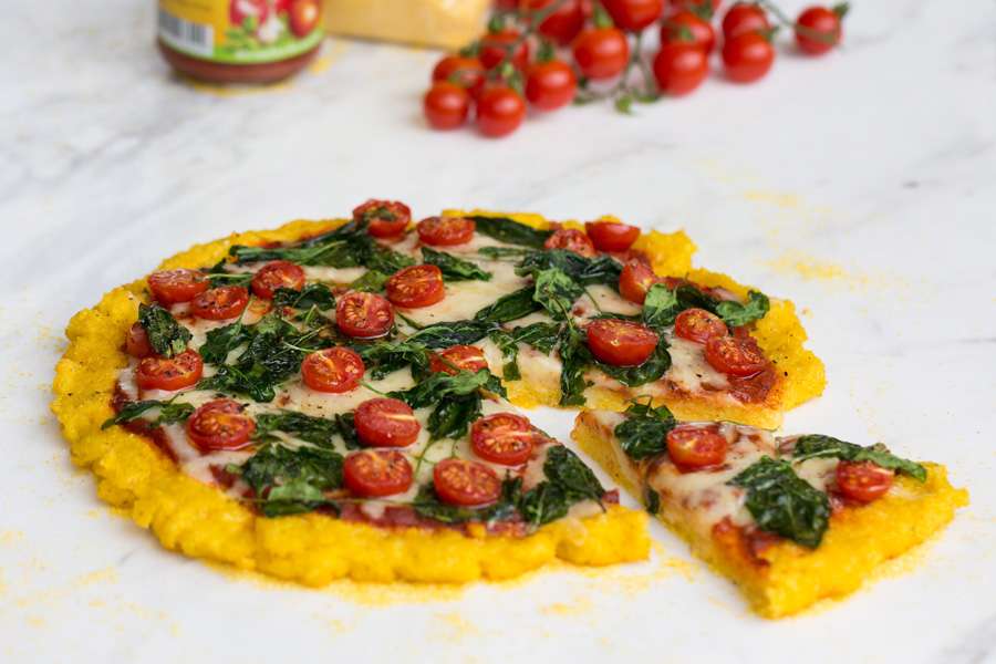 Polenta pizza with spinach and cherry tomatoes