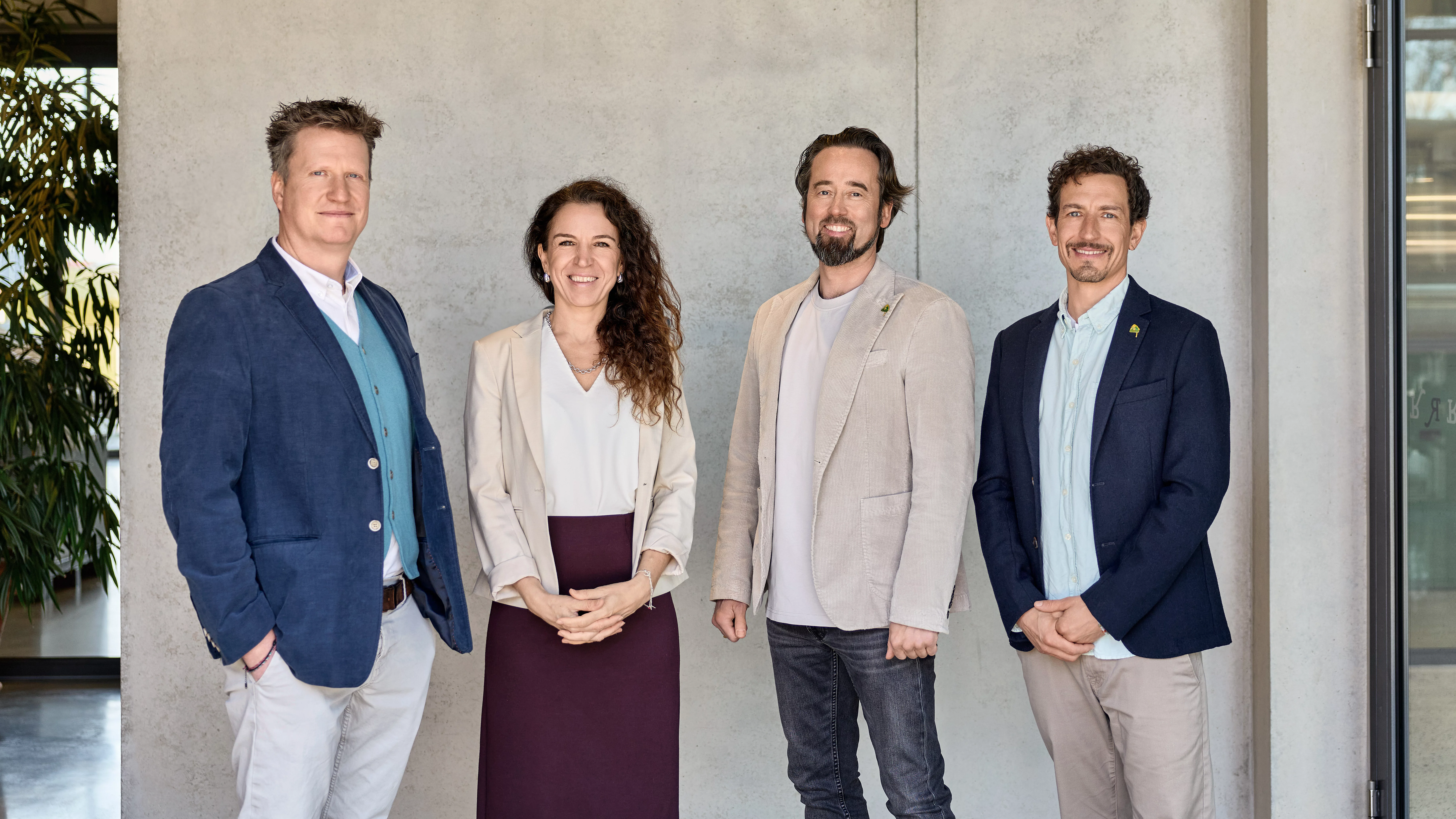 Alle Rapunzel Geschäftsführer stehen nebeneinander vor einer grauen Wand. Links steht Stefan Schmaus, daneben Seraphine Wilhelm, dann Werner Berlage. Rechts steht Leonhard Wilhelm. 