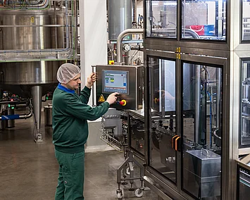 Mitarbeiter kontrolliert die Einstellungen an der Musanlage.