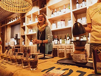 Kaffeeverkostung im Weinkeller der Rapunzel Welt. Rapunzel Mitarbeiterin präsentiert verschiedene Kaffeesorten im Weinkeller der Rapunzel Welt