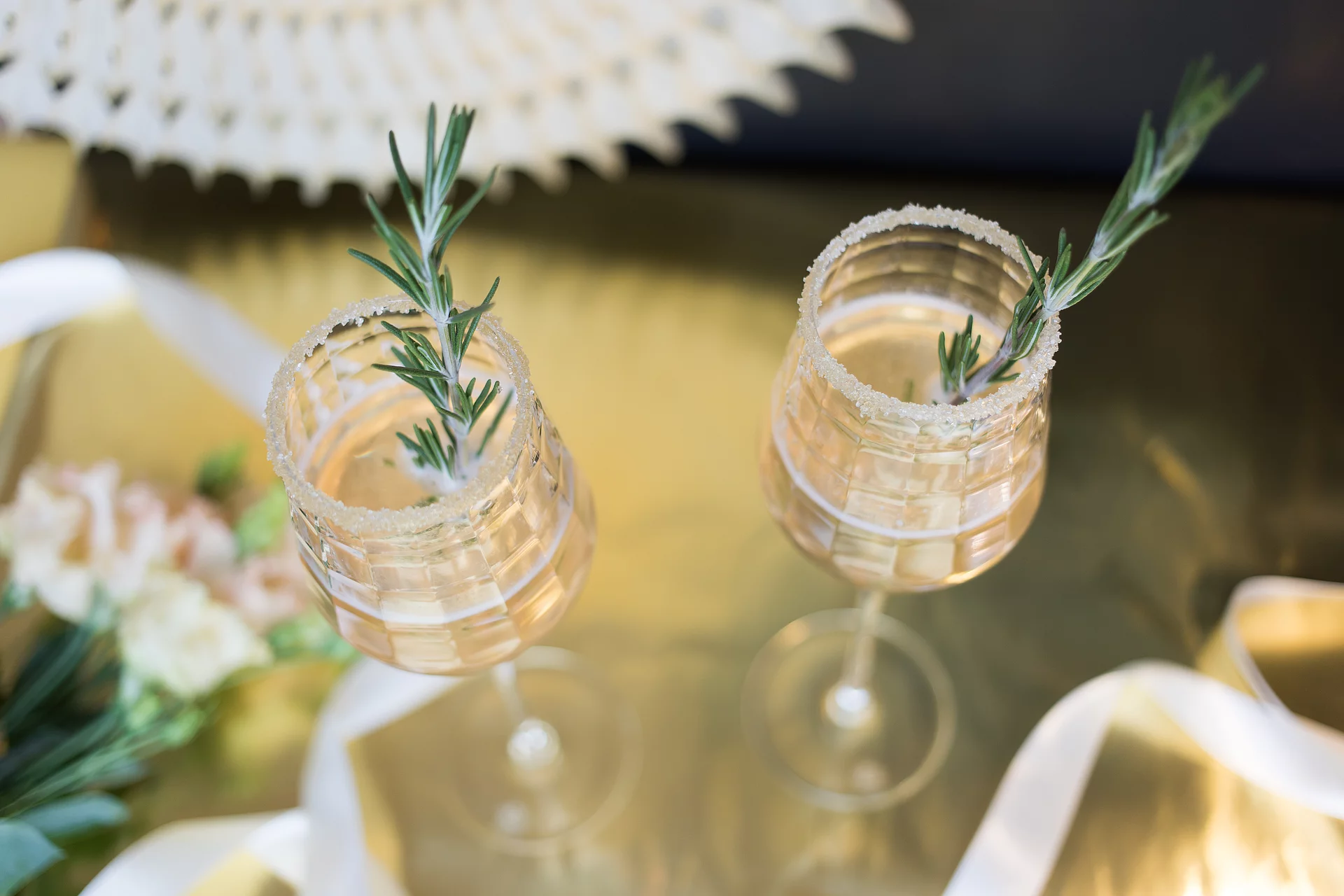 Rapunzel Prosecco mit Rosmarin-Stengel Rapunzel Prosecco mit Rosmarin-Stengel im Glas auf tisch in festlicher Atmosphäre