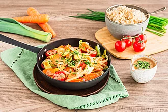 Gericht Gemüse mit Mandelsauce an Himalaya Basmati Reis Natur in einer Pfanne, daneben ein Teil der Zutaten.