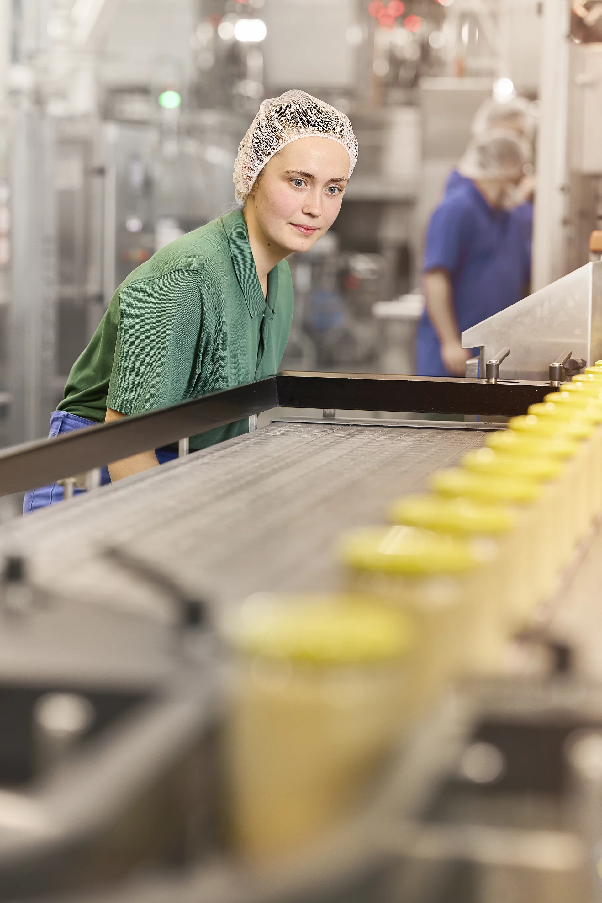 Rapunzel Mandelmus-Produktion – Teamarbeit. Drei Mitarbeitende halten ein Glas Mandelmus.