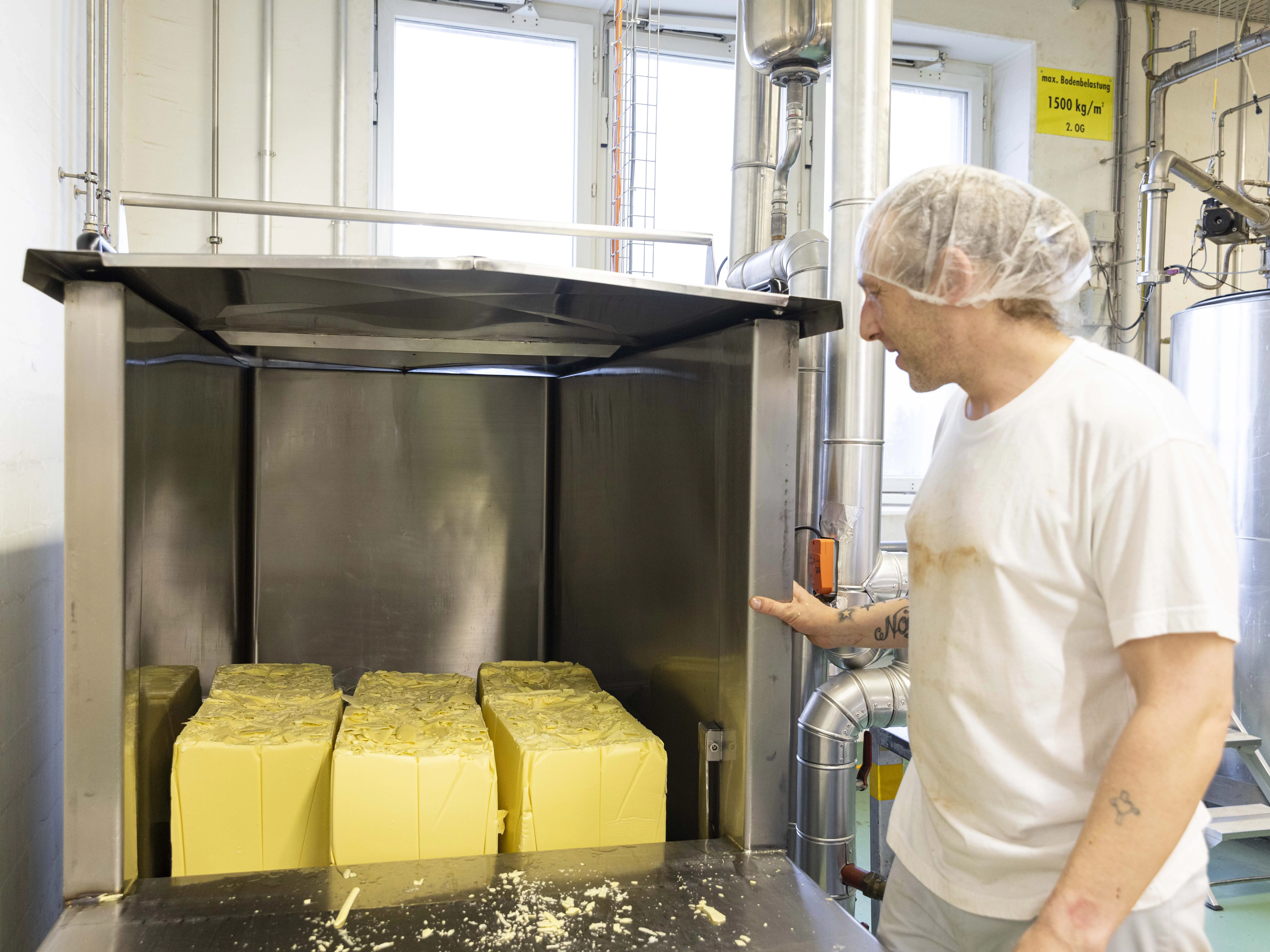 Maestrani Mitarbeiter schiebt Kakaobutter und Kakaomasse in die Schmelzöfen.