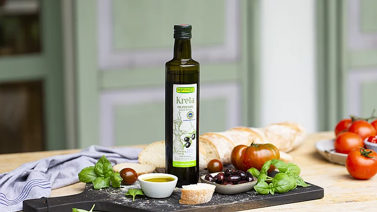 Dass Kreta Olivenöl steht auf einem Tisch im freien. Auf dem Tisch stehen kleine Mezzeteller mit Antipasti und Gemüse