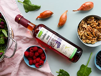 Rapunzel Condimento Rosso auf einer Küchenplatte umringt von Schüsseln mit Beeren und Nüssen