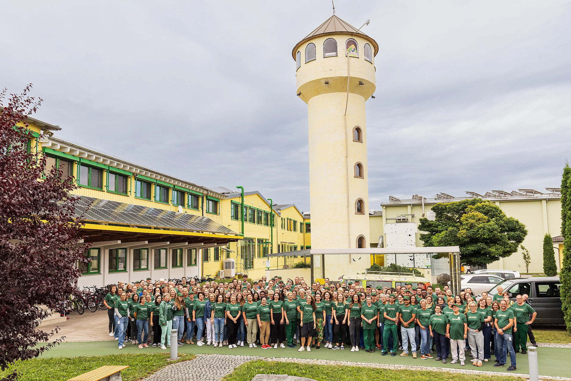 Gruppenfoto von Rapunzel Mitarbeitenden vor dem Unternehmensgebäude und dem Rapunzel Turm.