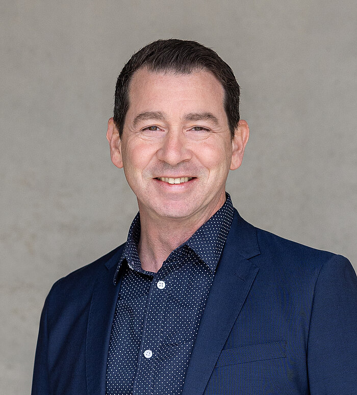 Mitarbeiter Rapunzel Presseteam vor grauer Betonwand.