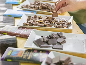 Auf einem Tisch stehen kleine Probierteller mit verschiedenen Sorten Rapunzel Schokolade. 