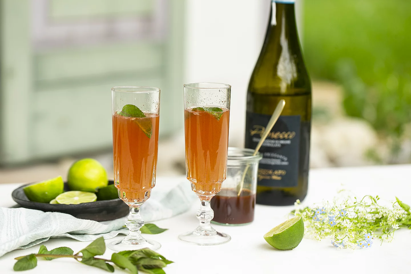 Wein und Prosecco von Rapunzel Prosecco von Rapunzel auf tisch im Freien, abgefüllt in Gläser mit Limette verfeinert