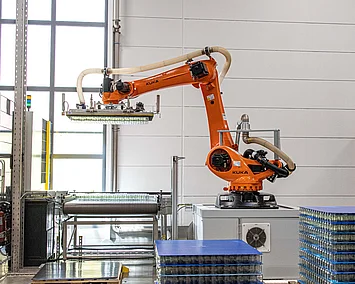 Vollautomatischer Roboter stapelt leere Gläser für die Nussmusabfüllung. 