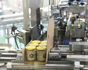 Produktionsbereich mit Nussmus-Gläsern und Verpackung.