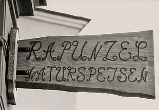 Das historische Ladenschild aus Holz mit der Aufschrift Rapunzel Naturspeisen.