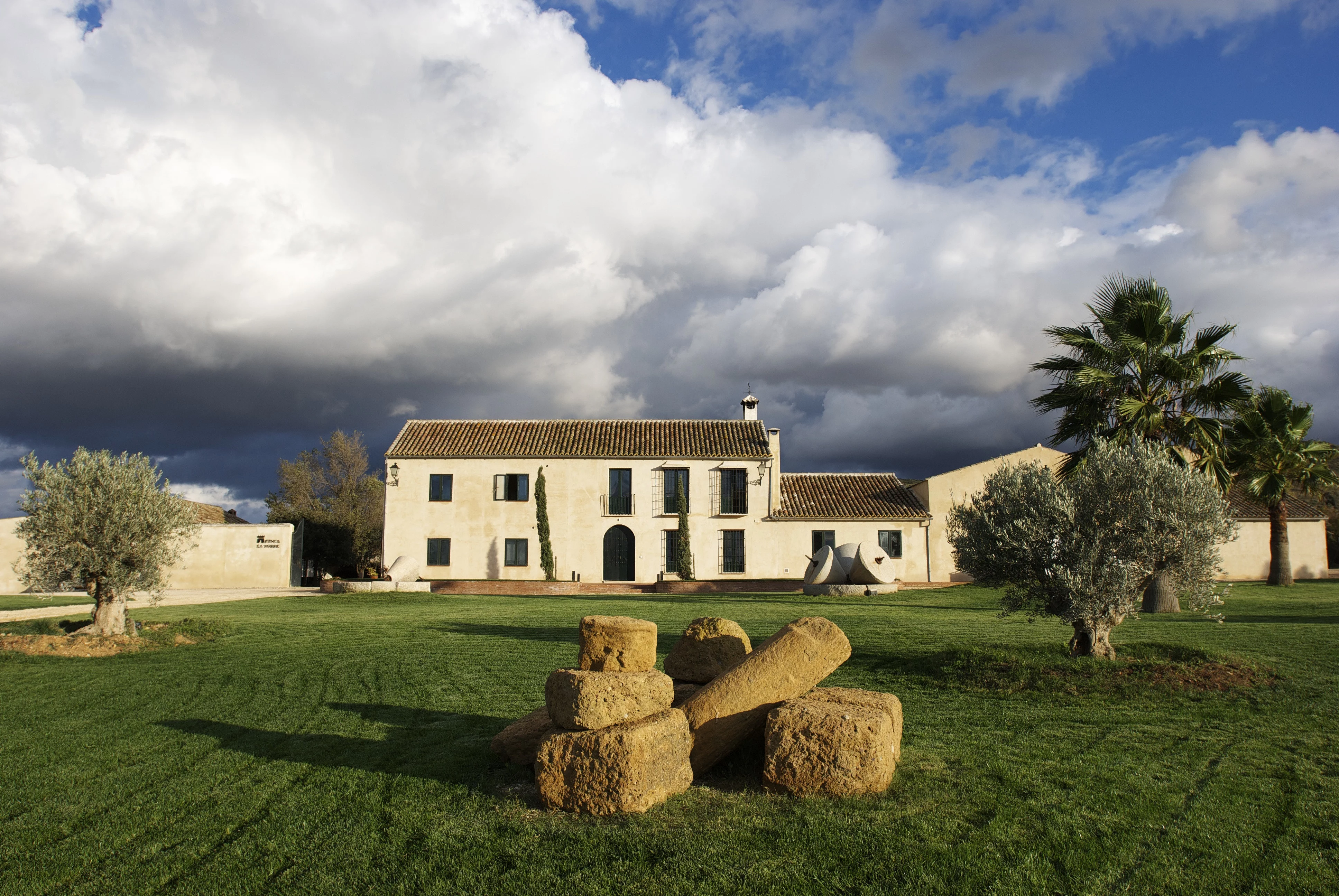 Gebäude der Finca La Torre inmitten der spanischen Landschaft, umgeben von Olivenhainen – Standort des Bio-Olivenöl-Anbaus und der eigenen Ölmühle.