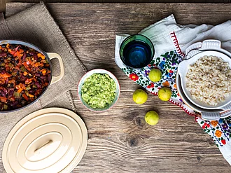 Chili sin carne in einem Topf neben einer Schüssel Parboiled Spitzenreis Langkorn Natur.