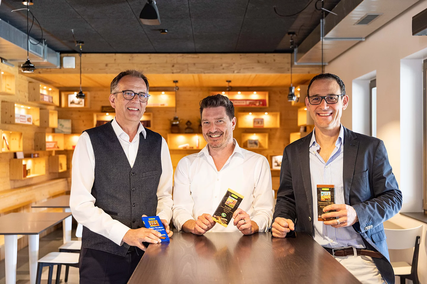 Günther Kscheschinski, Thomas Leitner und Christoph Birchler von Maestrani. Günther Kscheschinski, Thomas Leitner und Christoph Birchler halten Maestrani Schokoladen in die Kamera.