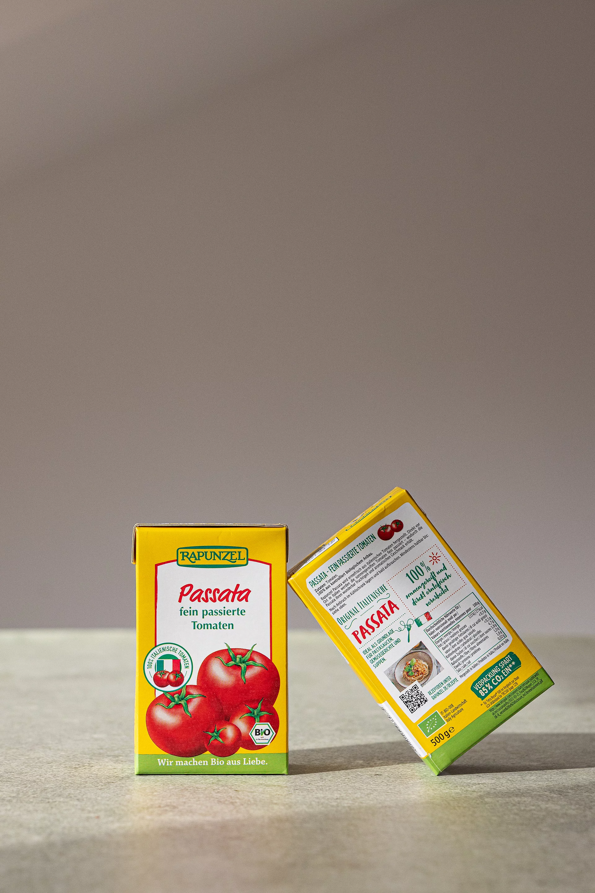 Zwei Rapunzel Passata Zwei Rapunzel Passata im Tetra Pack aneinandergelehnt auf Steinplatte