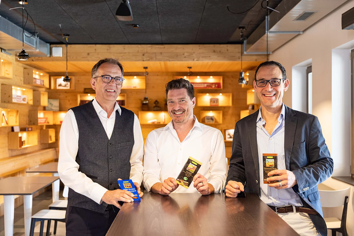 Günther Kscheschinski, Thomas Leitner und Christoph Birchler halten Maestrani Schokoladen in die Kamera.