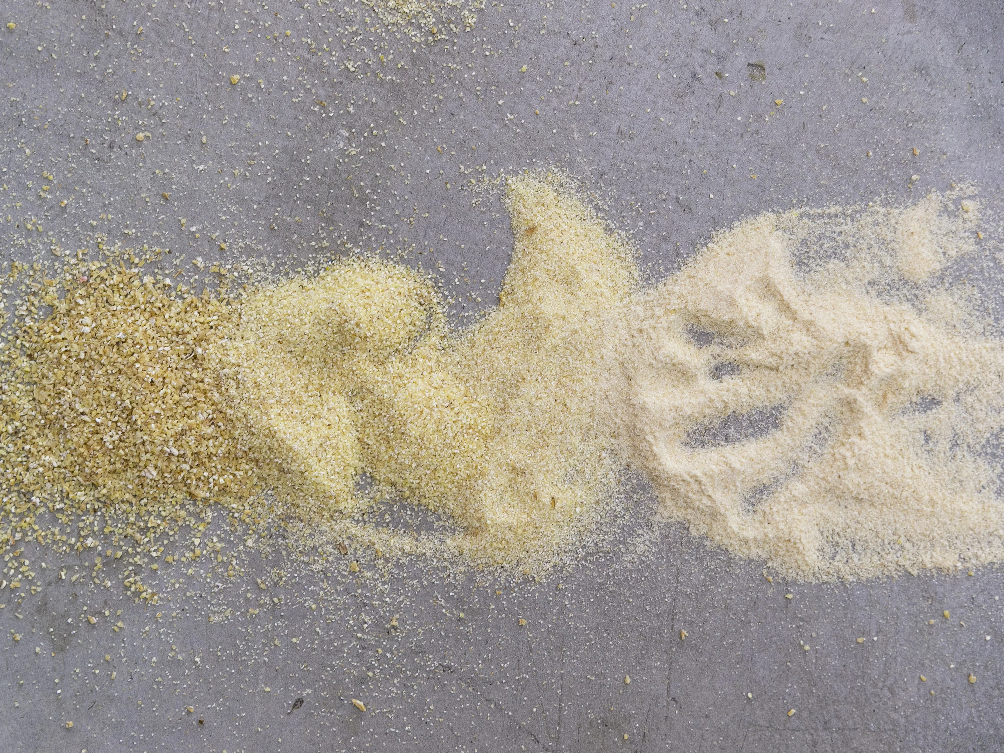 Grieß in verschiedenen Körnungen – von fein bis grob. Grieß in verschiedenen Körnungen auf Arbeitsfläche, von grob bis fein. Zum Grieß kommt nur reines Quellwasser.