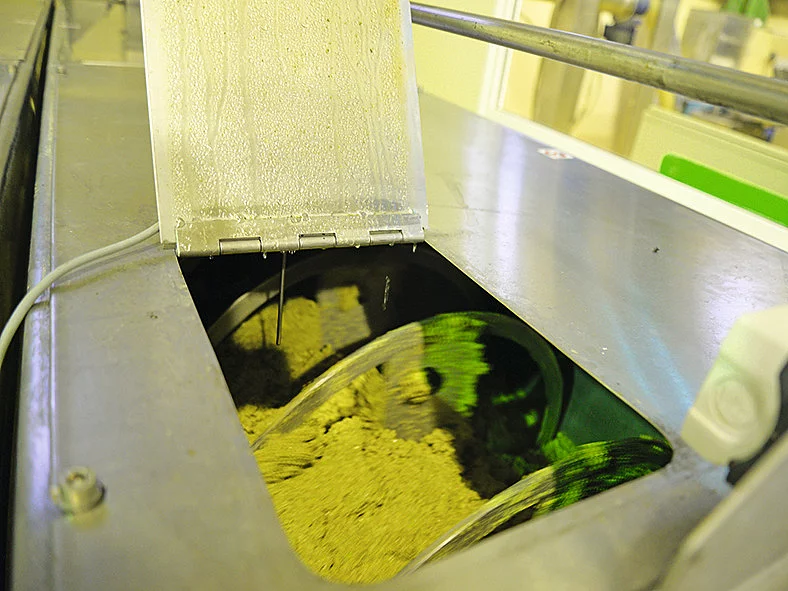 Knetprozess des Olivenbreis in der Ölmühle auf Kreta. Olivenbrei wird nach der Vermahlung in der Ölmühle auf Kreta bei niedriger Temperatur geknetet – wichtiger Schritt für Rapunzel Olivenöl.