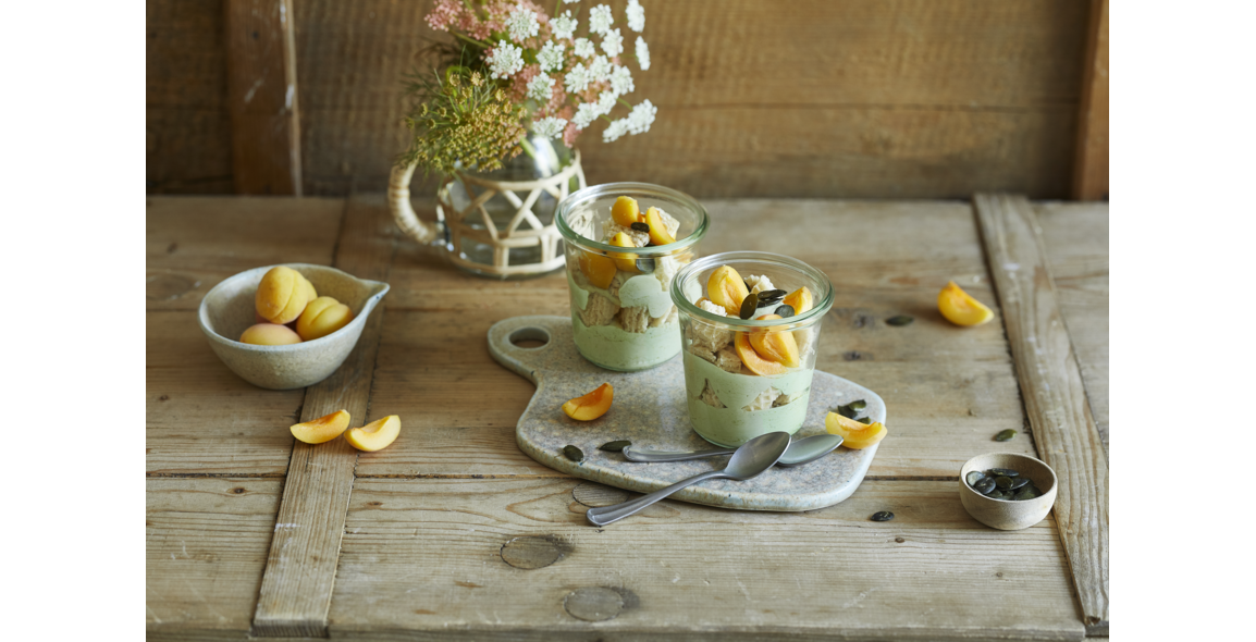 Grüne Kürbiskernöl-Mousse im Glas mit Aprikosen