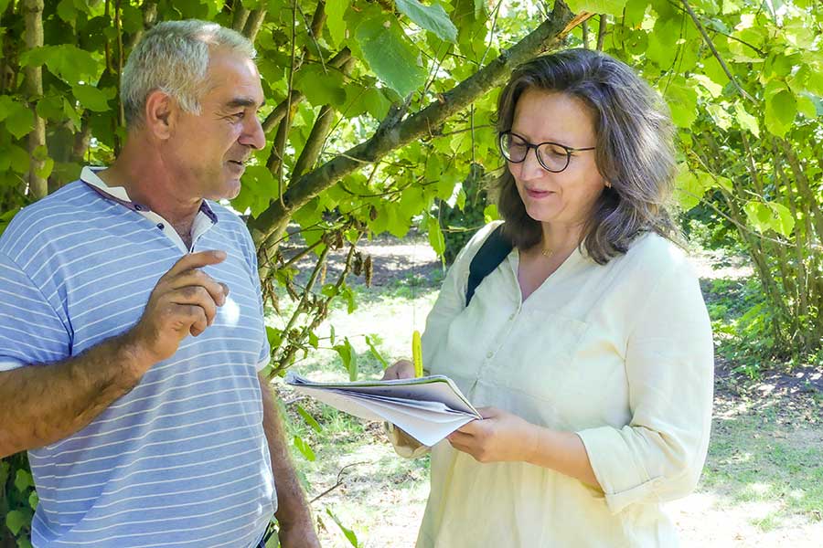 Barbara Altmann, head of raw material supply at Rapunzel, talks with hazelnut farmer Umudvar Jusifov.