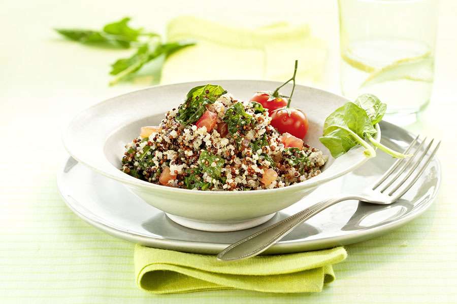 Quinoa risotto with tomatoes, spinach and cheese