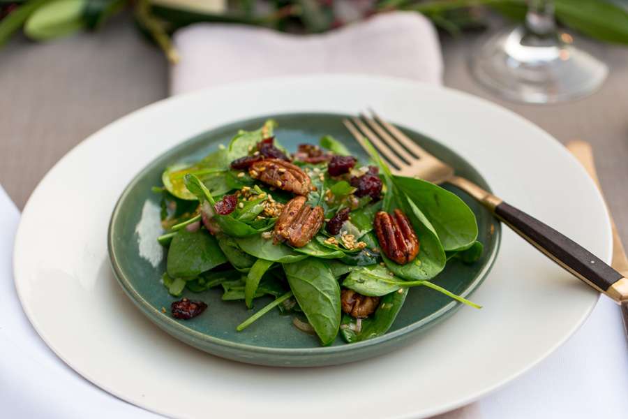 Kandierte Pekannüsse und Cranberries auf frischem Spinatsalat, mit geröstetem Sesam-Dressing