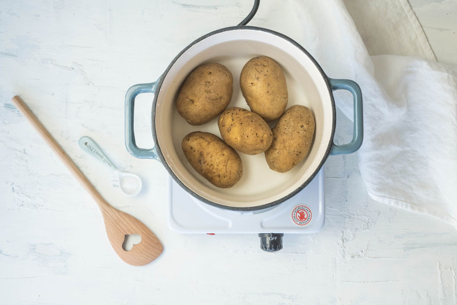 1. Die Kartoffeln waschen und ca. 20 Minuten (je nach Größe) in Salzwasser vorkochen bis sie bissfest gar sind.