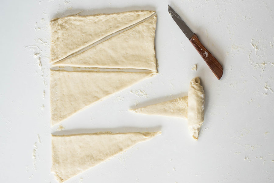 14. Die Dreiecke am unteren Ende 2 cm einschneiden und (die zwei Teile) soweit wie möglich auseinanderziehen. Dann die Teiglinge von der breiten Seite aufrollen. Wer möchte kann einen Teil der Croissants mit Schokolade füllen. 14. Die Dreiecke am unteren Ende 2 cm einschneiden und (die zwei Teile) soweit wie möglich auseinanderziehen. Dann die Teiglinge von der breiten Seite aufrollen. Wer möchte kann einen Teil der Croissants mit Schokolade füllen.