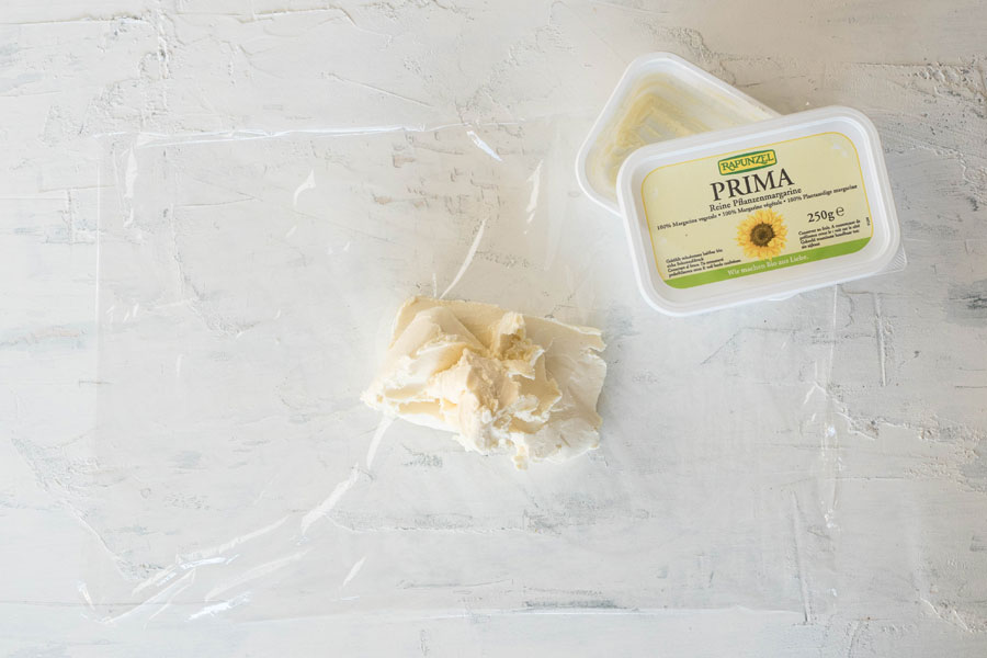 2. Die kalte Margarine in ein Stück Folie einschlagen... 2. Die kalte Margarine in ein Stück Folie einschlagen...